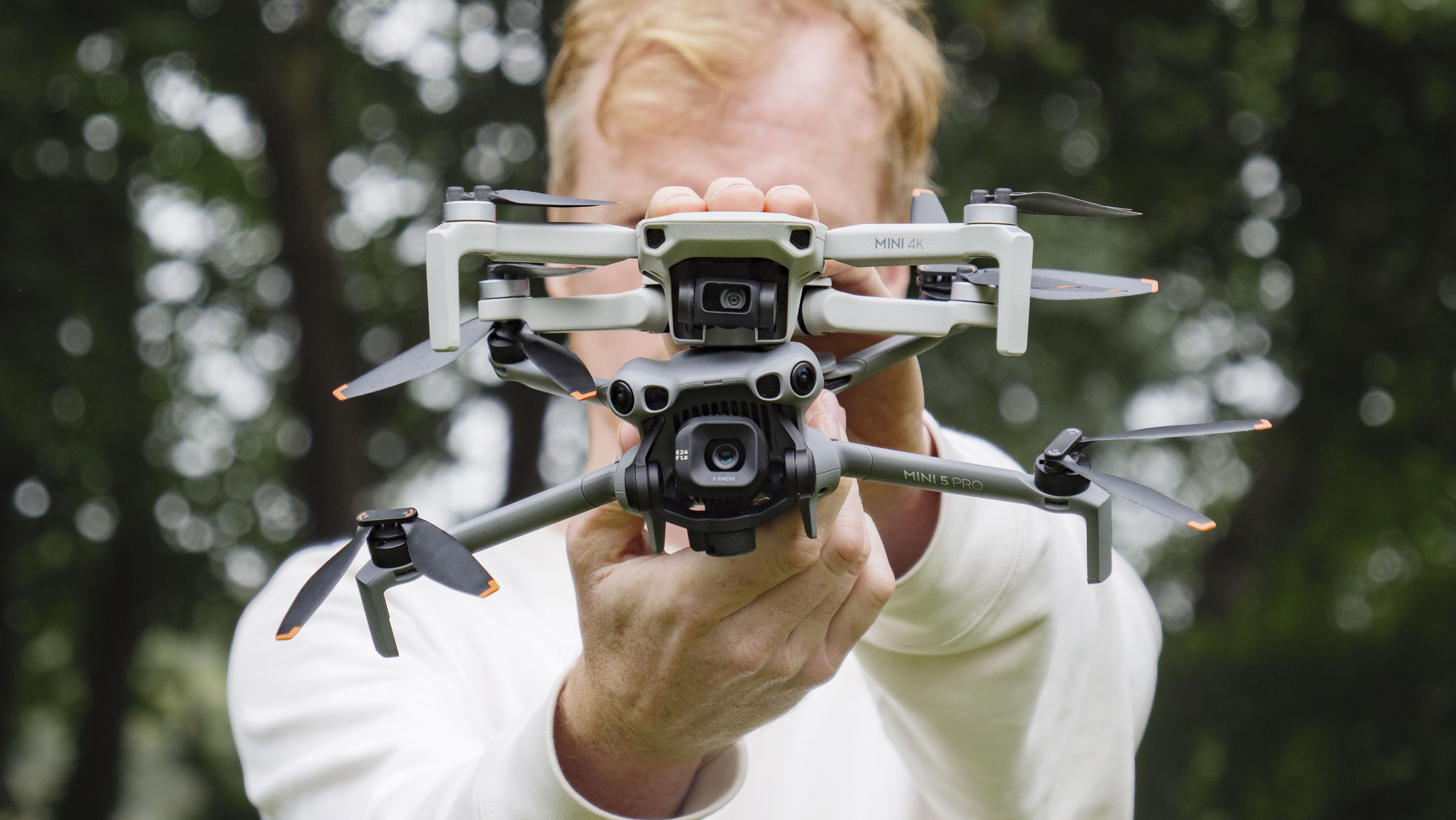 DJI Mini 5 Pro and DJI Mini 4K drones held by side by side